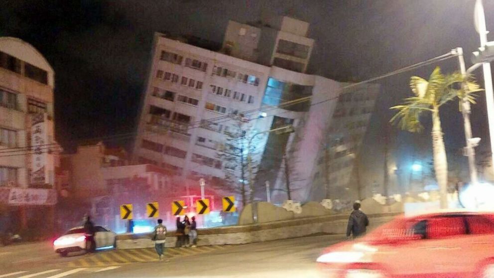 PHOTO: In this photo released by Hualien County Fire Bureau, rescuers are seen entering an building that collapsed onto its side from an early morning earthquake in Hualien County, eastern Taiwan, Feb. 7 2018.