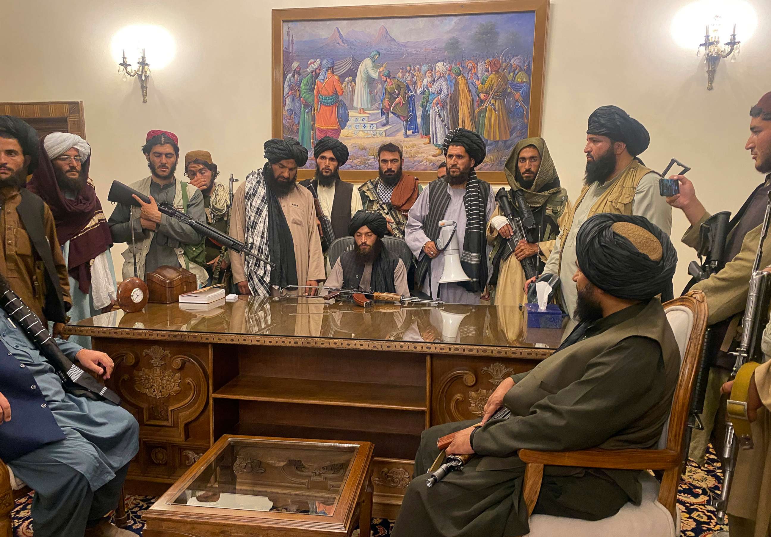PHOTO: Taliban fighters take control of Afghan presidential palace after President Ashraf Ghani fled the country, in Kabul, Aug. 15, 2021. An attendee holds a phone, recording the events.