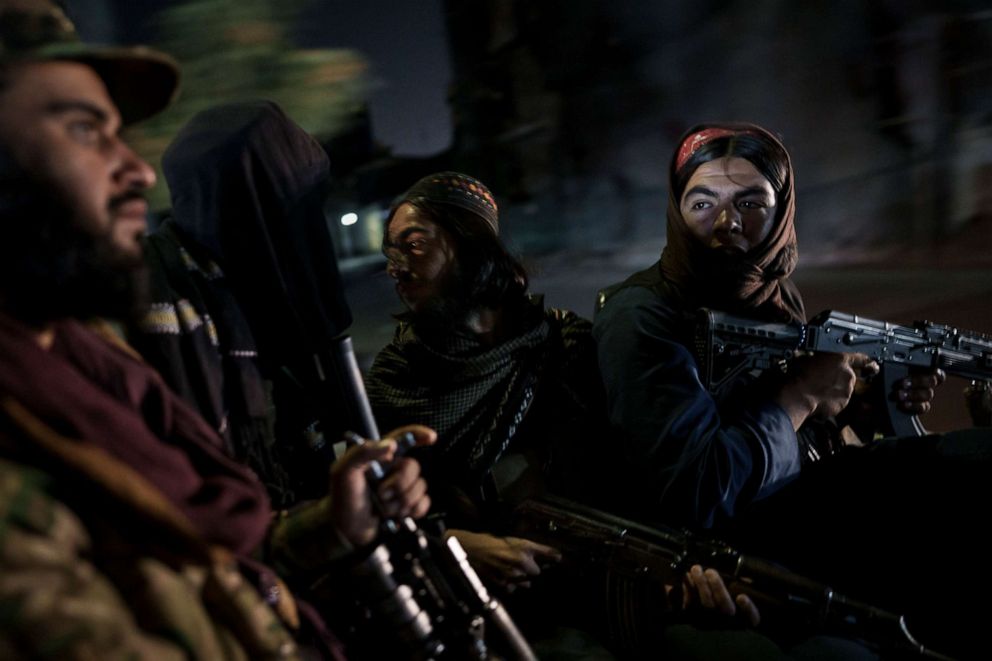 PHOTO: Taliban fighters ride in the back of a vehicle during a night patrol in Kabul, Afghanistan, Sept. 12, 2021.