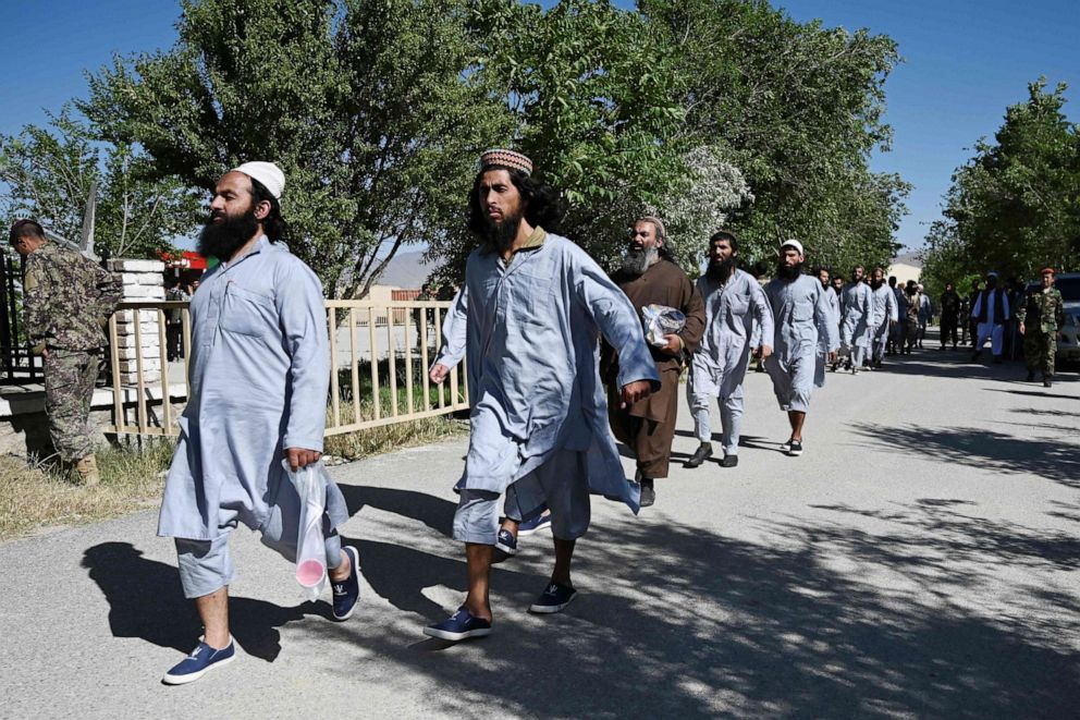 PHOTO: In this May 26, 2020, file photo, Taliban prisoners walk in line during their release from the Bagram prison, next to the US military base in Bagram, some 50 kms north of Kabul, Afghanistan.