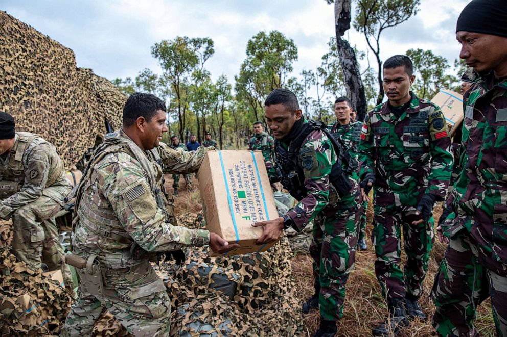 PHOTO: U.S. Army soldier hands over a Australian Defence Force combat ration to an Indonesian soldier during the Joint Pacific Multinational Readiness Center (JPMRC) rotation at Townsville Field Training Area (TFTA), Townsville, Australia, July 26, 2023.