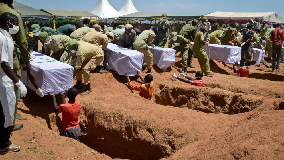 Coffins of some of the victims of the MV Nyerere passenger ferry capsizing are laid into graves during a mass burial ceremony on Ukara Island, Tanzania, Sunday, Sept. 23, 2018.
