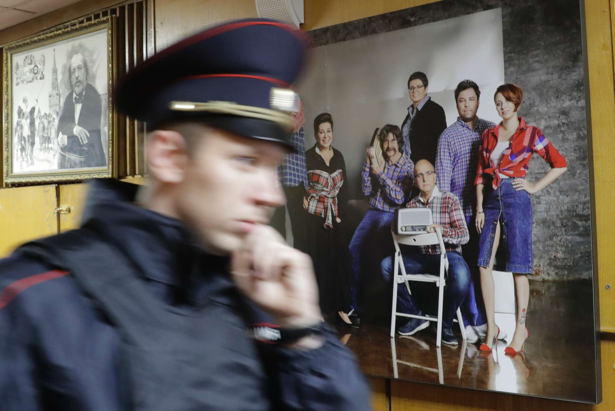 PHOTO: A policeman walks past a photograph showing the employees of Russian radio station Ekho Moskvy, including anchor Tatiana Felgengauer, right, at the station's office in Moscow, Oct. 23, 2017.