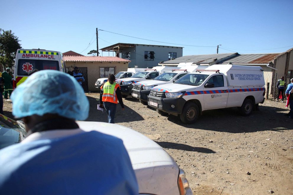 FOTO: Camionetas de la morgue se ven mientras el personal forense lleva los cuerpos de las víctimas después de la muerte de los clientes encontrados dentro de Enyobeni Tavern en Scenery Park, en las afueras de East London, en la provincia de Eastern Cape de Sudáfrica, el 26 de junio de 2022.