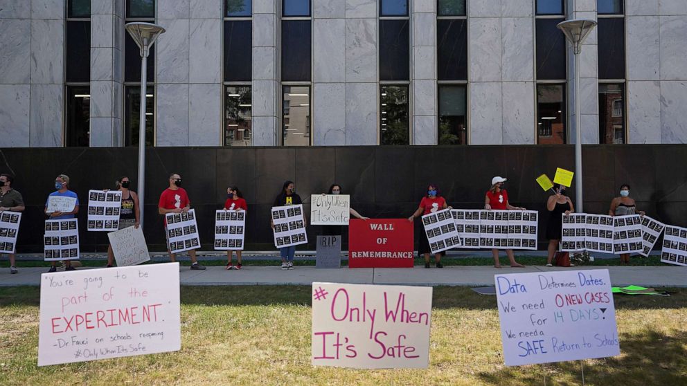 PHOTO: Teachers and community members from the group NJ21United show images of 400 teachers who died from COVID-19 and hold other signs during a rally, in front of Governor Phil Murphy's office in Trenton, NJ., on Aug. 3, 2020.