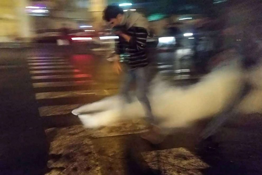 PHOTO: A protester covers his face to protect himself from tear gas during a demonstration against an increase in gasoline prices in the capital Tehran, Nov. 16, 2019. 