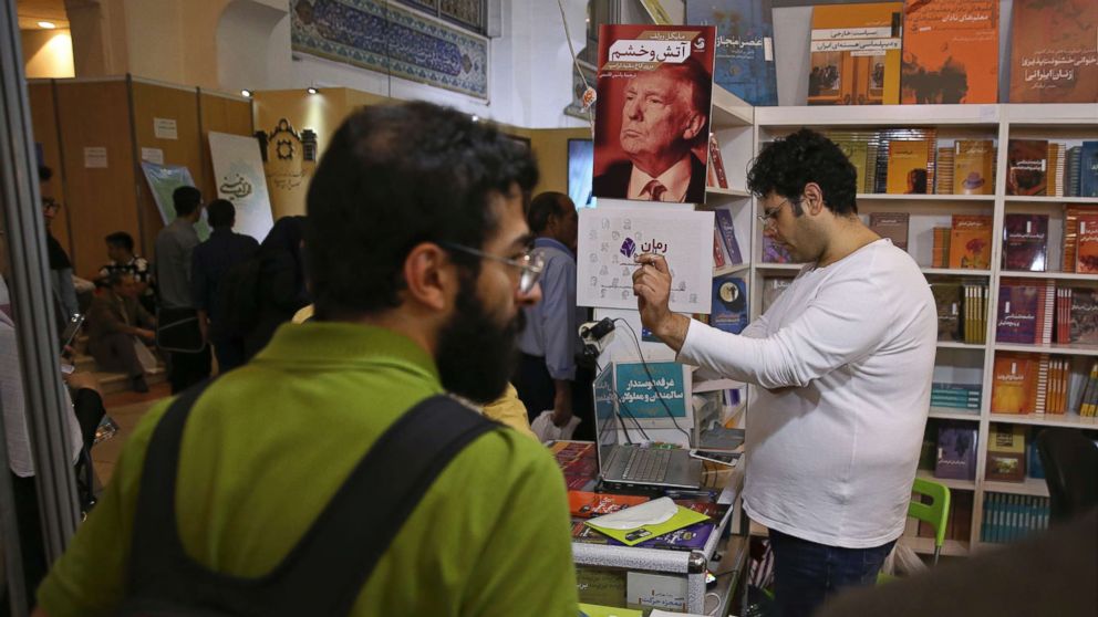 A poster advertising the farsi translation of the book, "Fire and Fury," by Michael Wolff. is displayed at a booth at the International Book Fair, in Tehran, Iran, Tuesday, May. 8, 2018.
