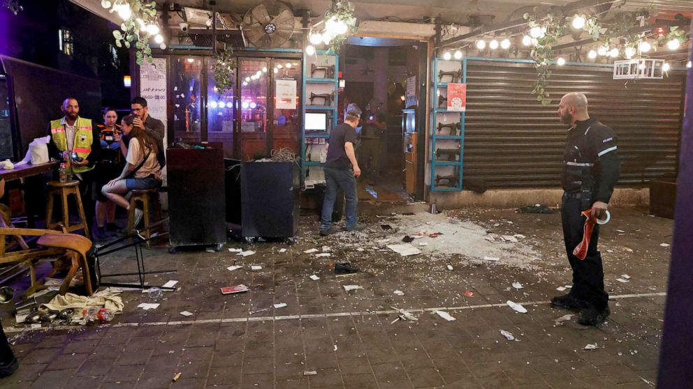 PHOTO: People walk through the scene of a shooting attack at a cafe in Disengoff Street in the center of Tel Aviv, Israel, April 7, 2022.