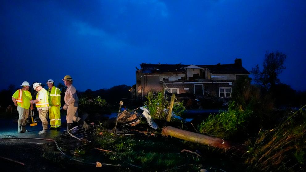 PHOTO: Utility workers survey storm damage along Cothran Road, Wednesday, May 8, 2024, in Columbia, Tennessee.