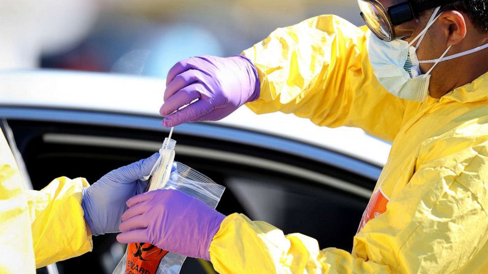 PHOTO: A medical professional collects a sample after administering a coronavirus test to a patient at a drive-thru coronavirus testing site, April 6, 2020 in Jericho, New York.