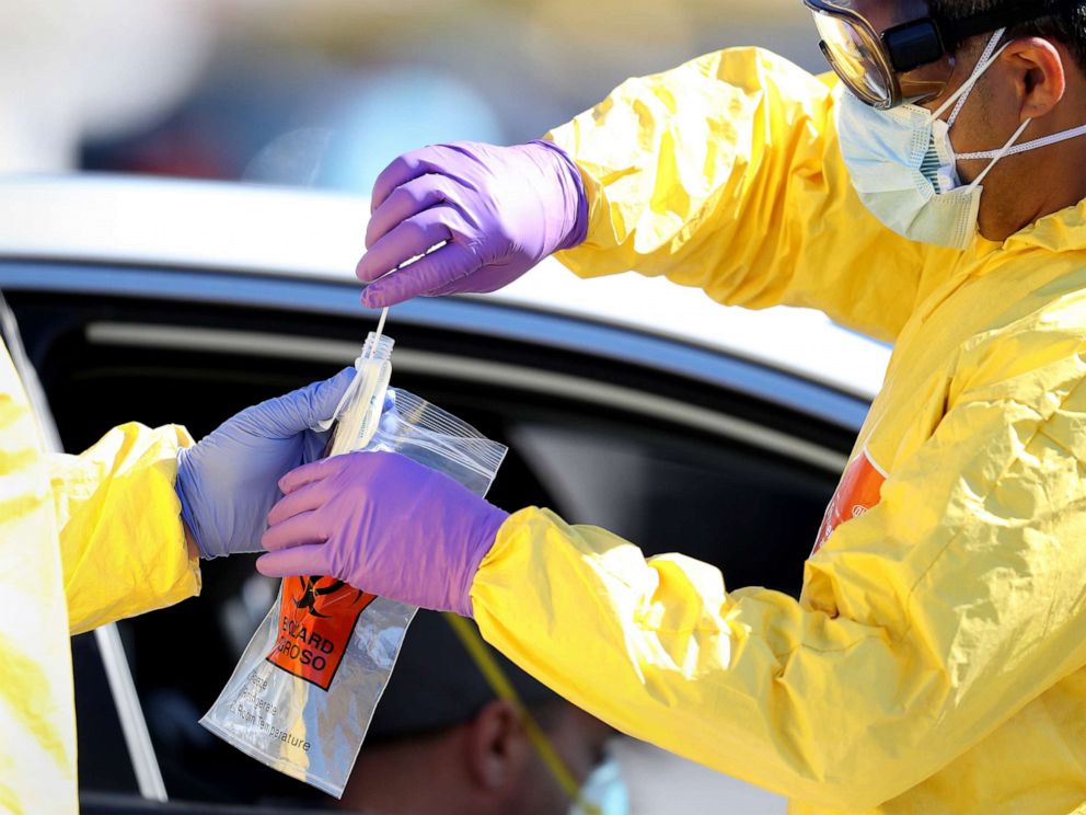 PHOTO: A medical professional collects a sample after administering a coronavirus test to a patient at a drive-thru coronavirus testing site, April 6, 2020 in Jericho, New York.