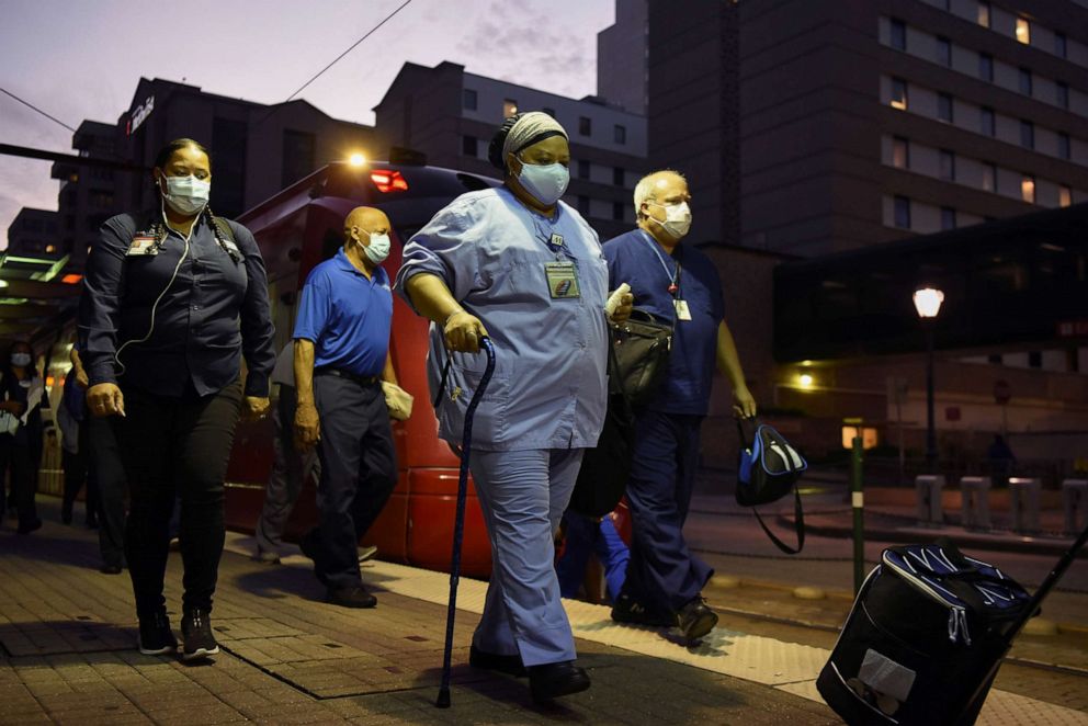 PHOTO: Healthcare workers walk through the Texas Medical Center during a shift change as cases of COVID-19 spike in Houston, July 8, 2020.