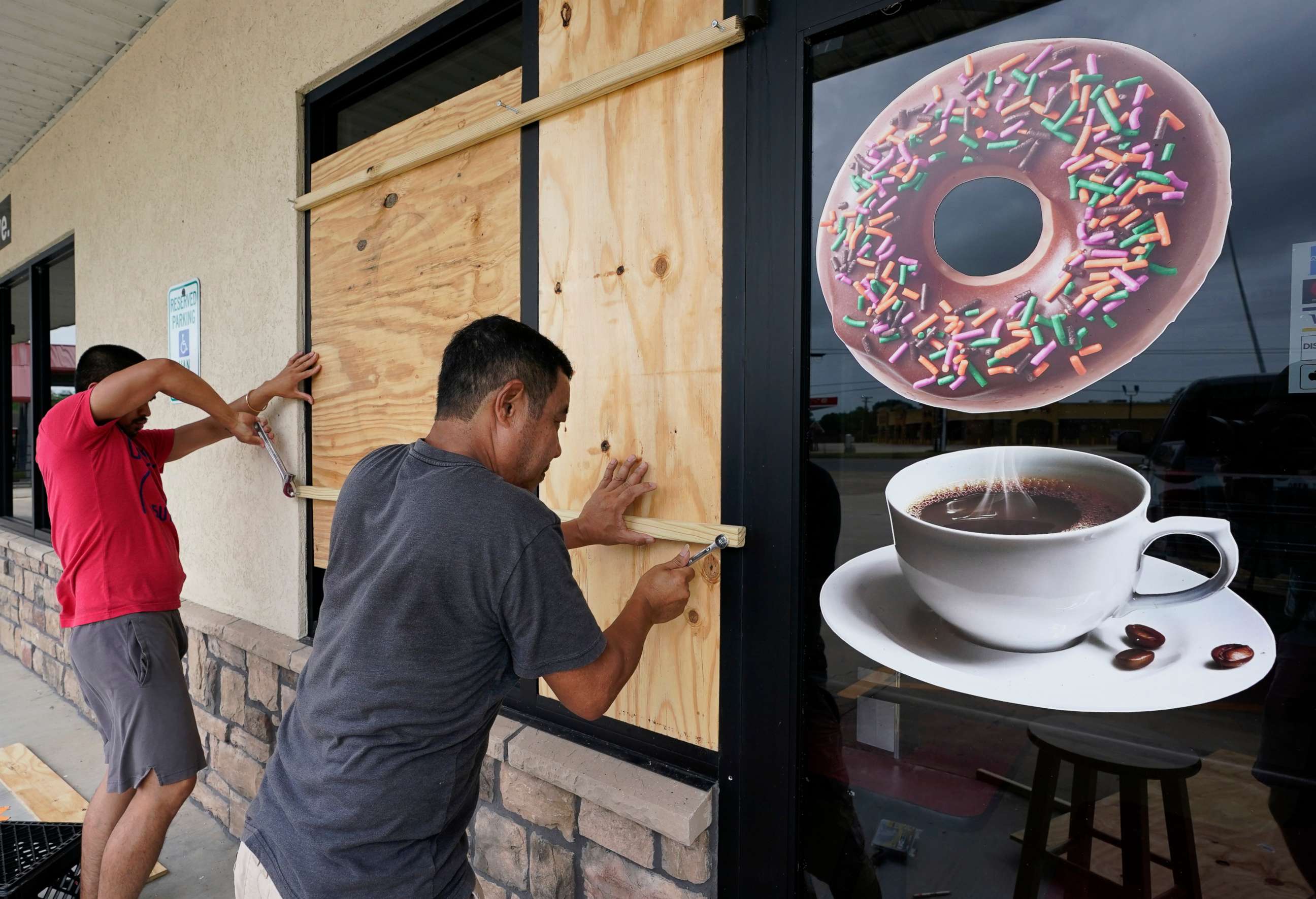 PHOTO: Daoith Porm, left, and Bunsant Khov, right, board up their business as Hurricane Laura approaches, Aug. 26, 2020, in Bridge City, Texas.
