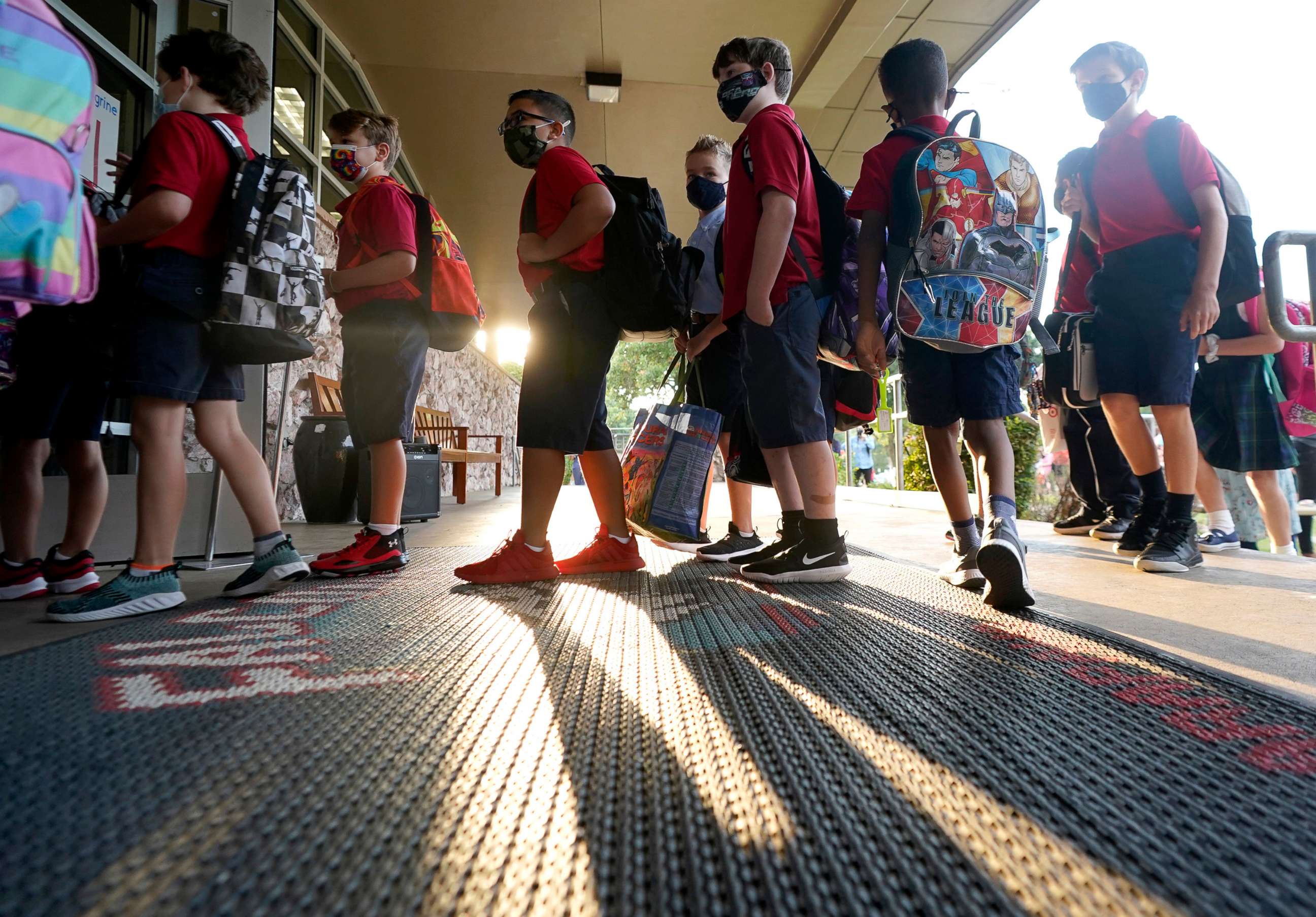 PHOTO: Wearing masks to prevent the spread of COVID-19, elementary school student line up to enter school for the first day of classes in Richardson, Texas, Aug. 17, 2021.