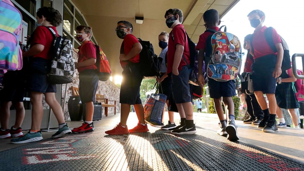 PHOTO: Wearing masks to prevent the spread of COVID-19, elementary school student line up to enter school for the first day of classes in Richardson, Texas, Aug. 17, 2021.