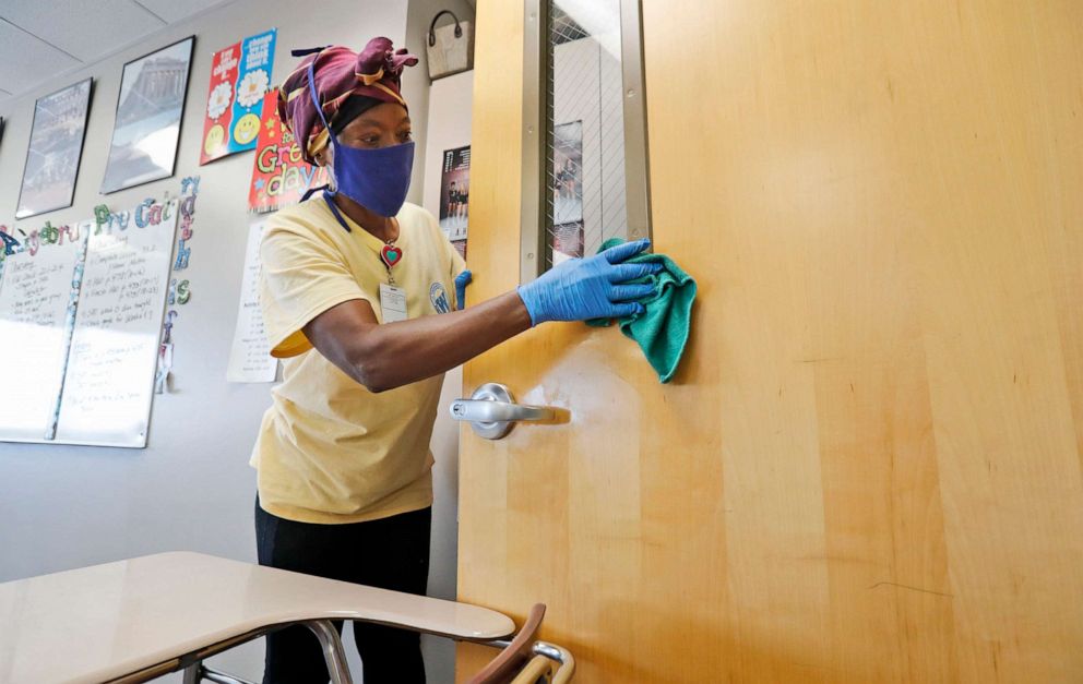 PHOTO: Amid concerns of the spread of COVID-19, Alma Odong wears a mask as she cleans a classroom at Wylie High School in Wylie, Texas, July 14, 2020.