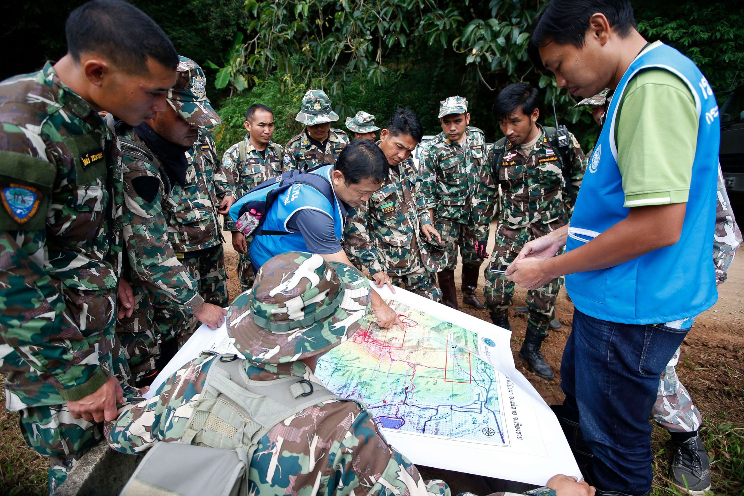 PHOTO: Thai forest rangers examine a map to view possible drilling options during the ongoing rescue operations for the child soccer team and their assistant coach, in Chiang Rai province, Thailand, July 7, 2018.