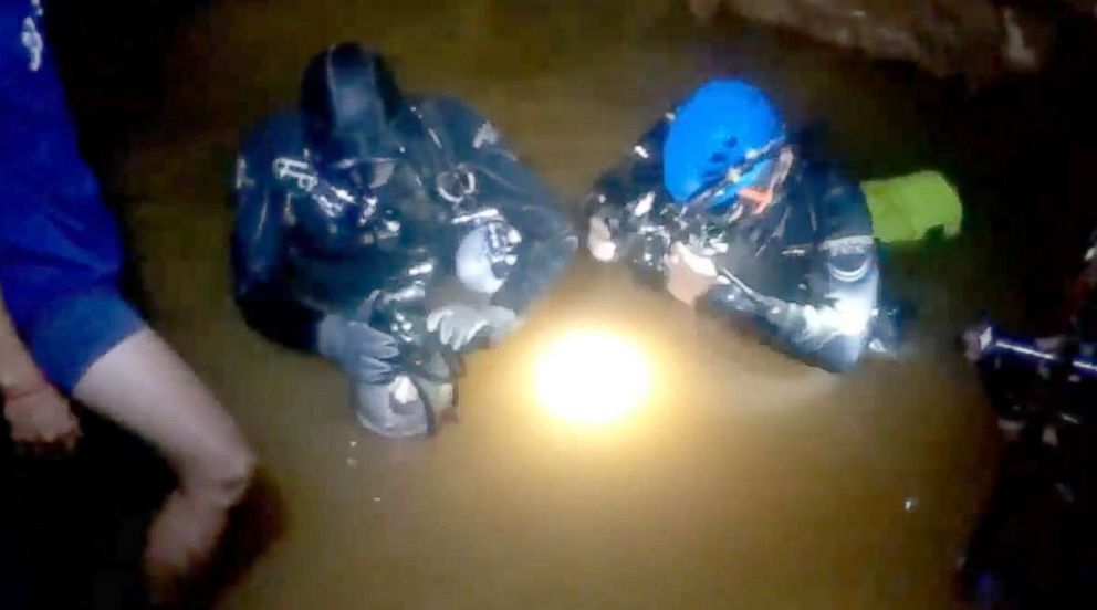 PHOTO: :  Two divers prepare their masks and air-tank regulators as they gear up for the scuba mission through the narrow flooded passageway leading to the cavern where each of the 12 boys and their coach.