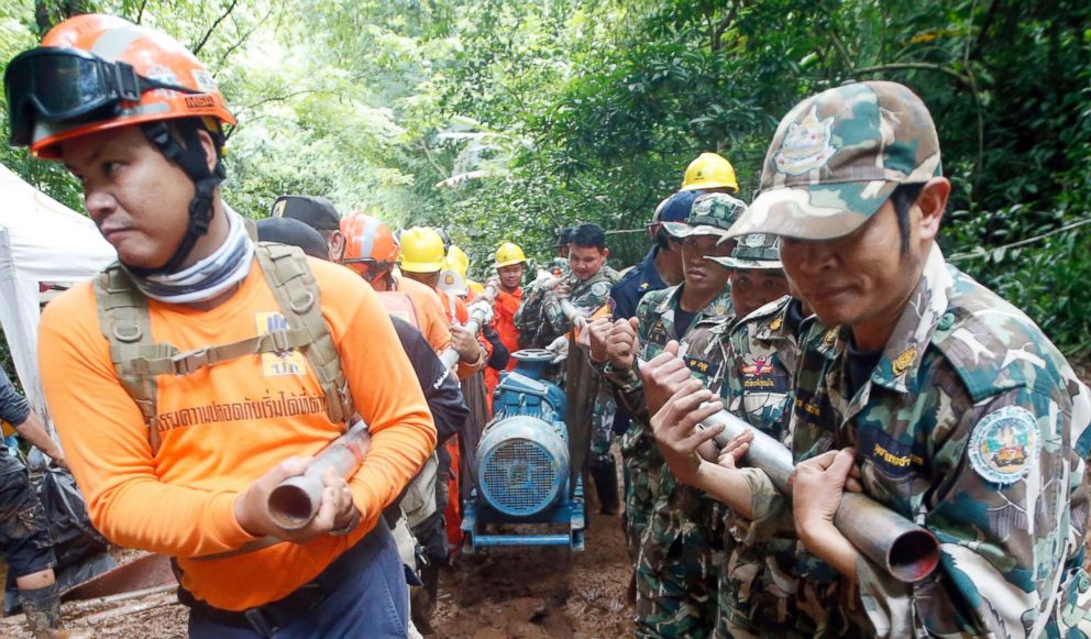 PHOTO: Rescue personnel drag a water pump  up to the flooded cave that a soccer team and their coach are believed to be missing in, June 28, 2018, in Mae Sai, Chiang Rai province, in northern Thailand.