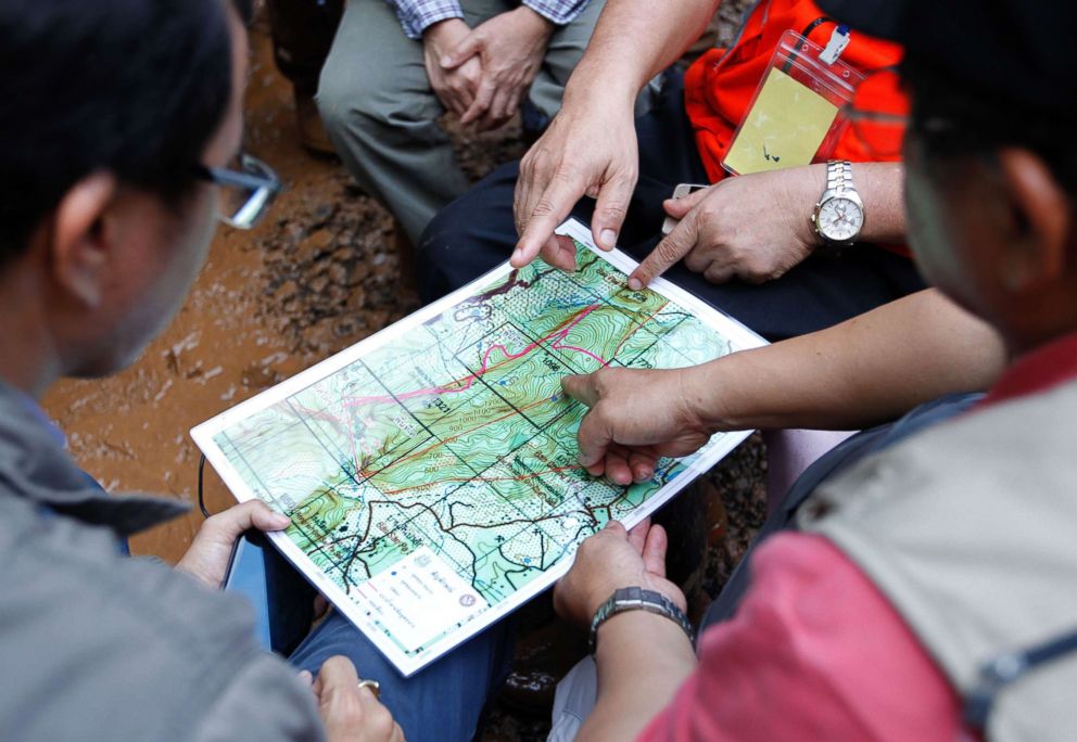 PHOTO: Thai associated officials are studying maps of the Tham Luang cave area, during the rescue operation for missing football players and their coach in Tham Luang Khun Nam Nang Noon Forest Park in Chiang Rai province, Thailand, June 28, 2018.