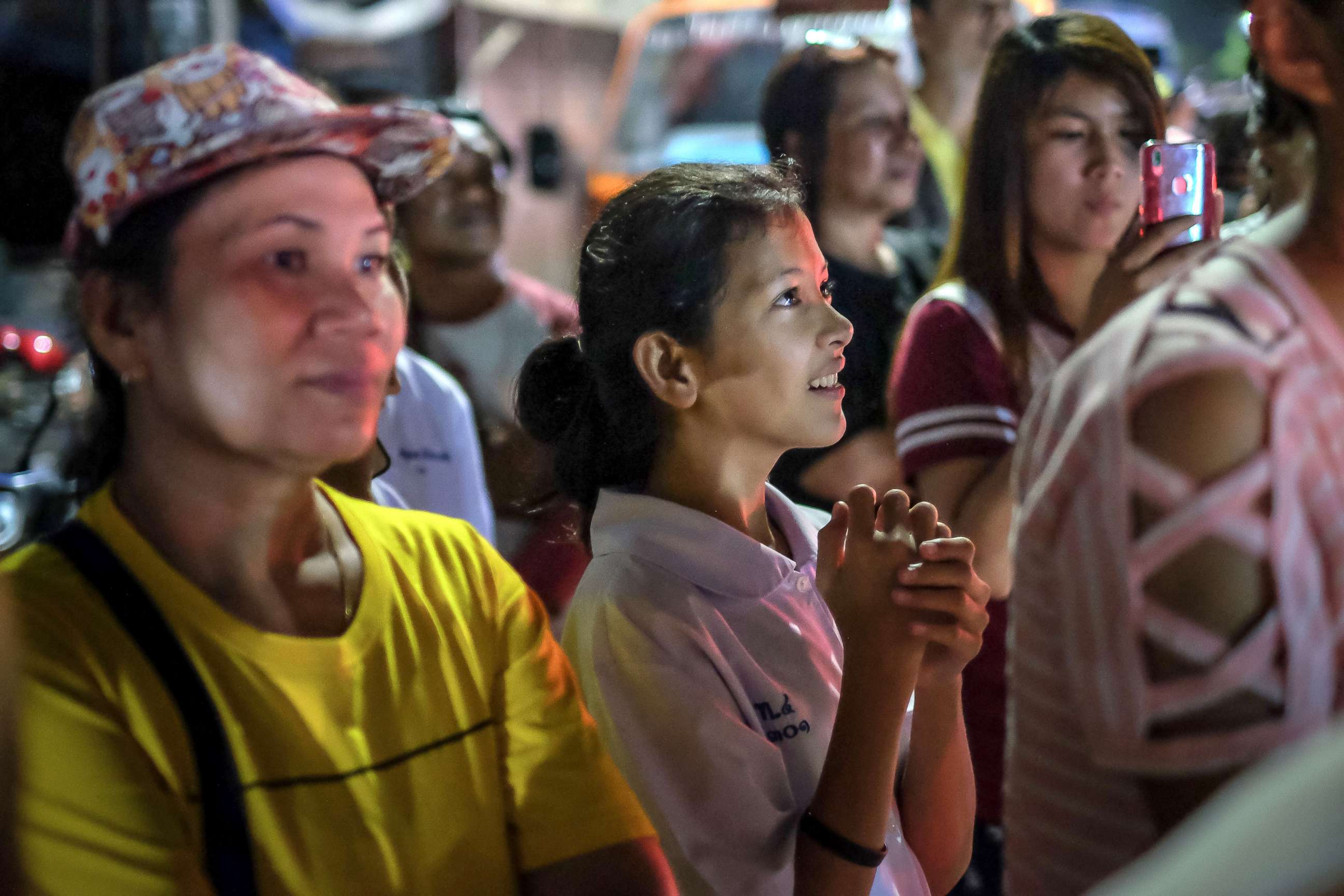 PHOTO: Onlookers at the junction in front of Chiangrai Prachanukroh Hospital watch and cheer as ambulances transport the last rescued schoolboys and their coach, July 10, 2018, in Chiang Rai, Thailand.