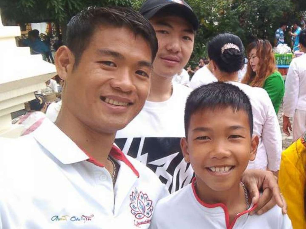 PHOTO: Eakkapon Chanwong, 25, the coach of Thai youth soccer team Wild Boars is pictured with Chanin Wiboonrungrueng, 11, center.