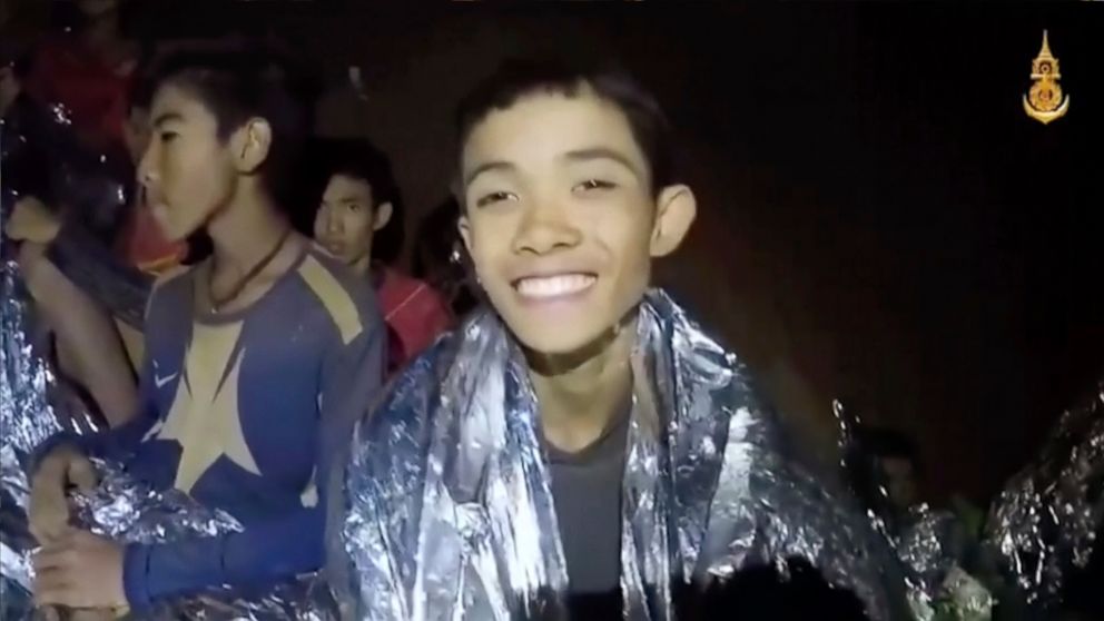 PHOTO: In this July 3, 2018, image taken from video provided by the Royal Thai Navy Facebook Page, a Thai boy smiles as Thai Navy SEAL medic help injured children inside a cave in Mae Sai, northern Thailand.