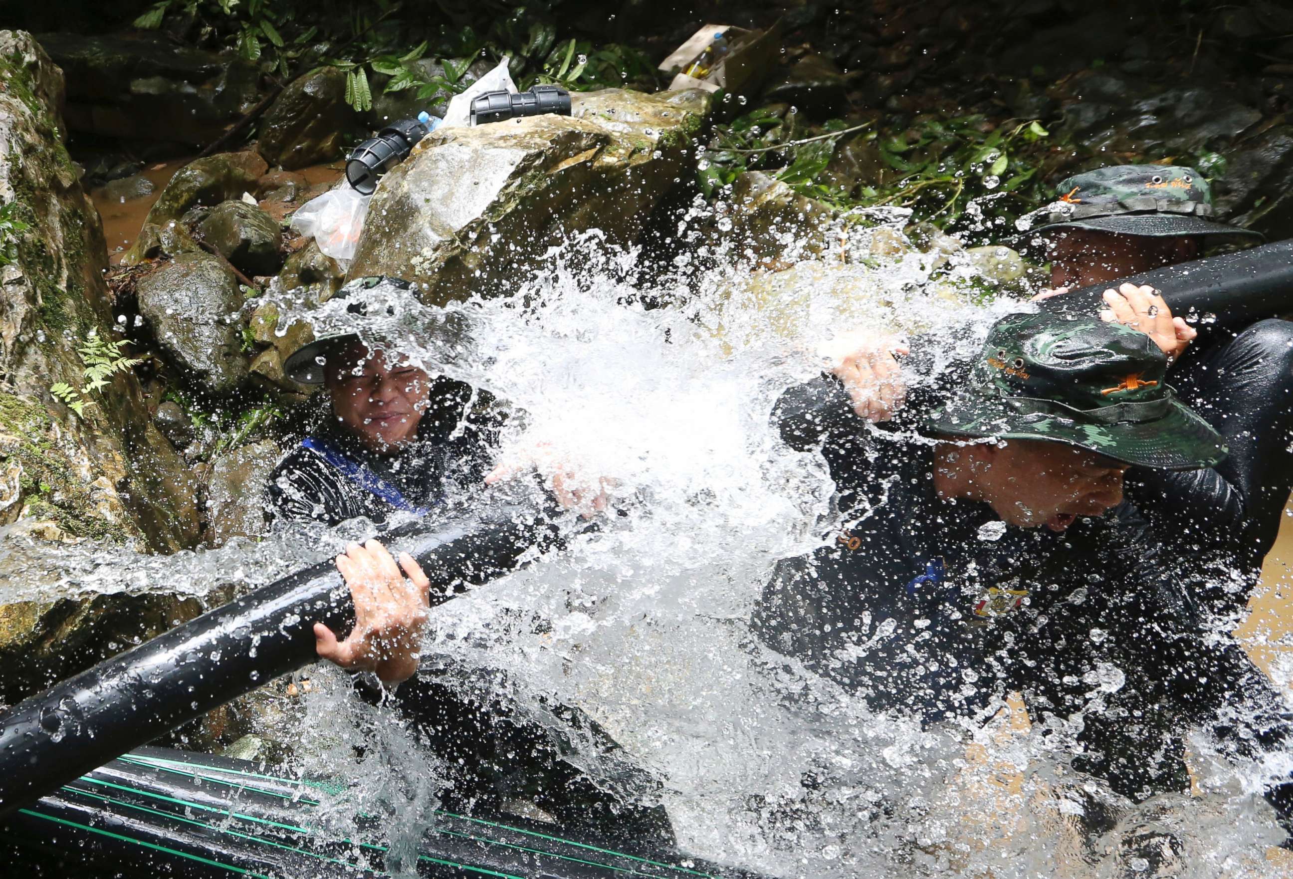 PHOTO: Thai soldiers try to connect water pipes that will help bypass water from entering a cave where 12 boys and their soccer coach have been trapped since June 23, in Mae Sai, Chiang Rai province, in northern Thailand, July 7, 2018. 