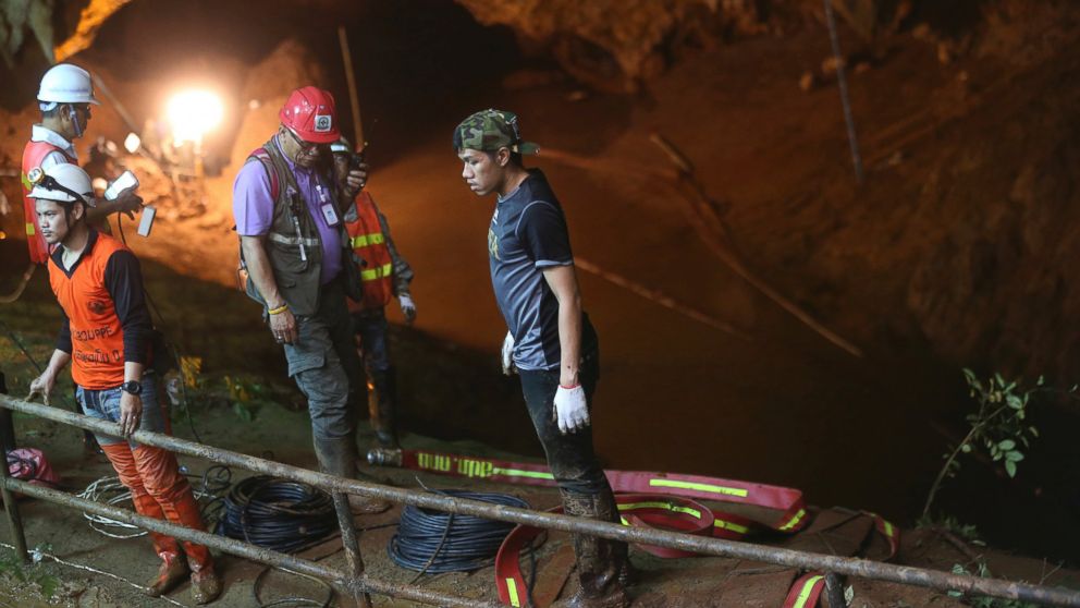 Rescue personnel walk out of the entrance to a cave complex where it's believed that 12 soccer team members and their coach went missing, Thursday, June 28, 2018, in Mae Sai, Chiang Rai province, in northern Thailand.