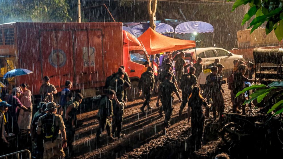A group of policemen walks out of Tham Luang Nang Non cave where a a soccer team has gone missing, June 29, 2018, in Chiang Rai, Thailand.