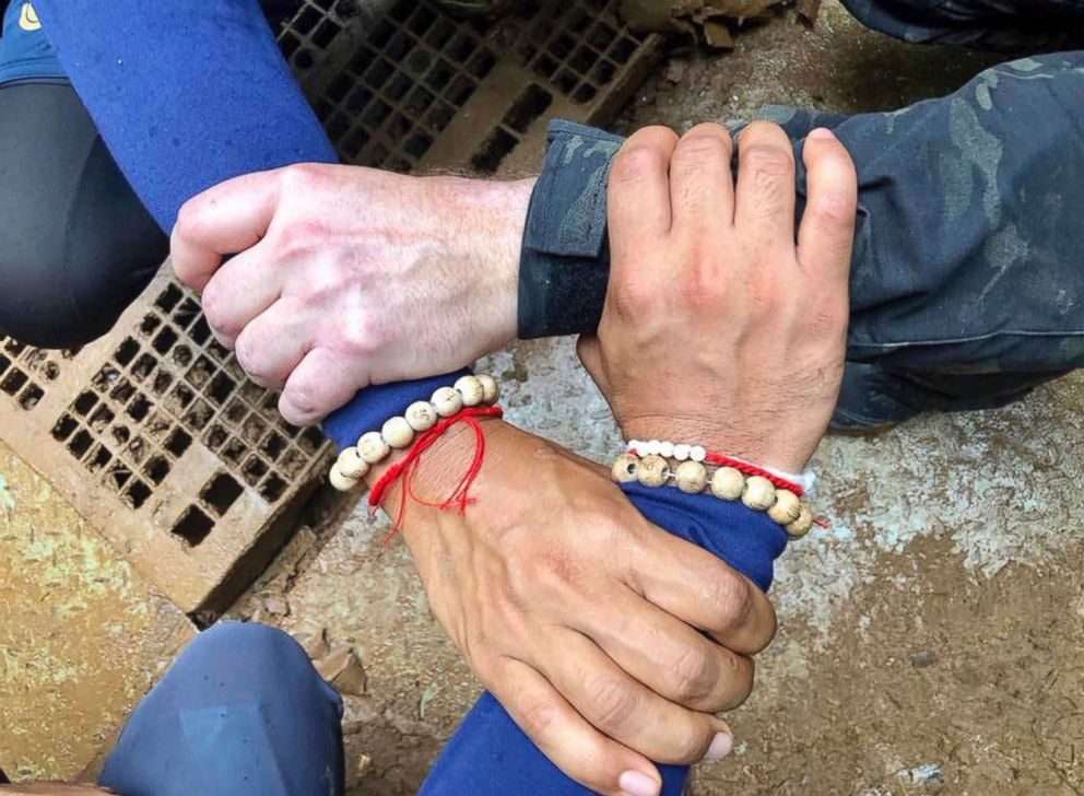 PHOTO: This undated photo released via the Thailand Navy SEAL Facebook page on July 8, 2018 shows rescuers hands locked with a caption reading "We Thai and the international teams join forces to bring the young Wild Boars home."