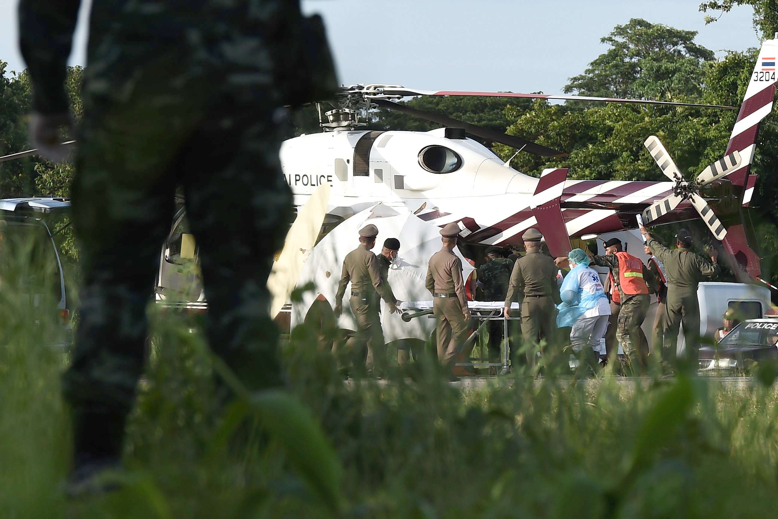 PHOTO: Rescue workers bring a stretcher close to a police helicopter at a military airport in Chiang Rai on July 9, 2018, as rescue operations continue for those still trapped inside the cave in Khun Nam Nang Non Forest Park in the Mae Sai district.