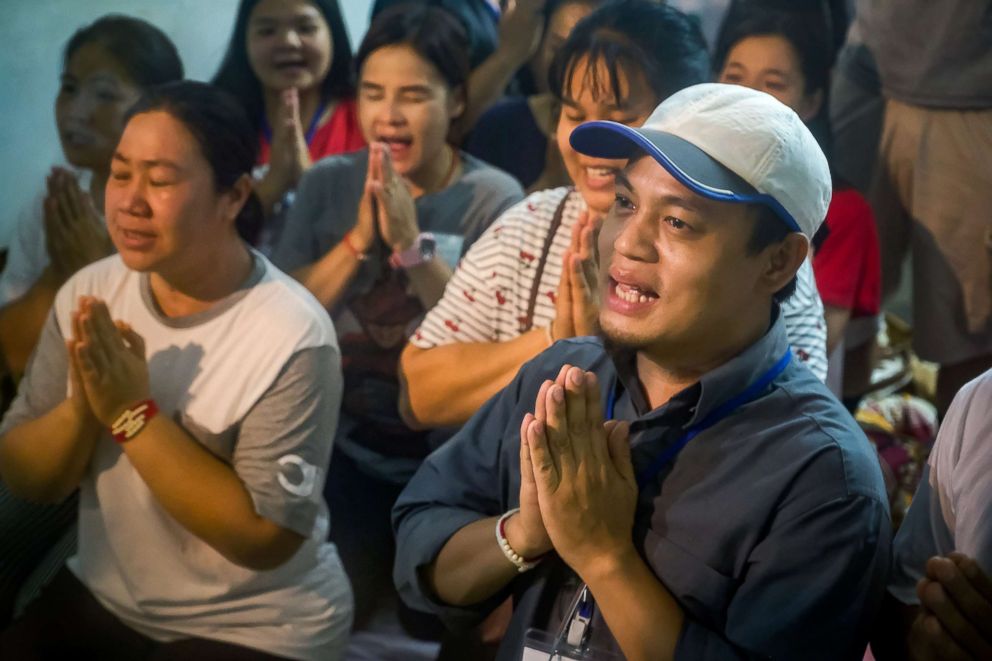 PHOTO: Relatives of the missing boys pray, after the 12 boys and their soccer coach have been found alive in the cave where they've been missing for over a week after monsoon rains blocked the main entrance, July 02, 2018, in Chiang Rai, Thailand. 
