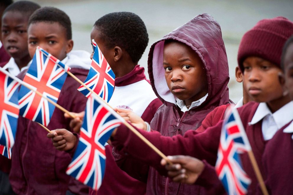 PHOTO: Schoolchildren hold British flags upon the arrival of the Britain's Prime Minister at ID Mkhize Secondary School in Gugulethu township, Aug. 28, 2018.