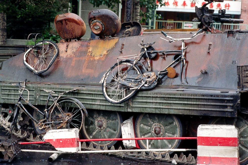 PHOTO: Mangled bicycles hang off the side of a PLA tank, which was burned by student protesters in Tiananmen Square, Beijing.