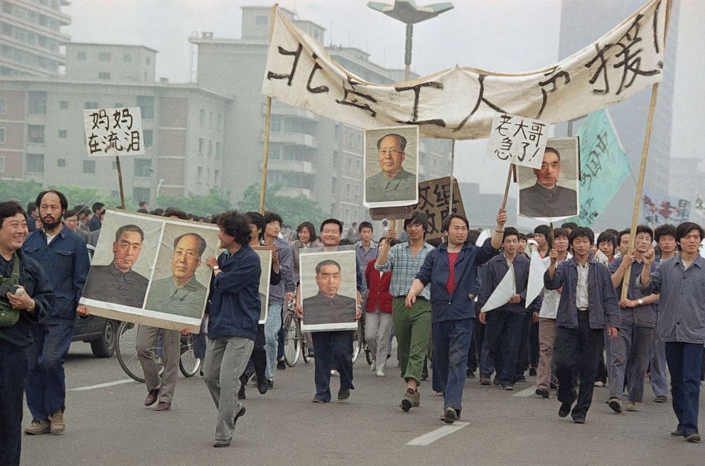 PHOTO: Pro-Democracy demonstrators carry portraits of former Chinese rulers Mao Tse-Tung and Chou En-Lai as they march to join student strikers at Tiananmen Square, Beijing, May 18, 1989.