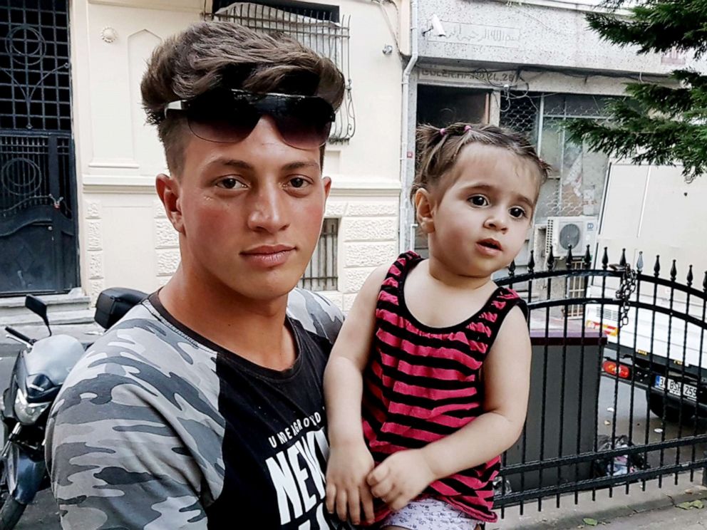 PHOTO: Algerian citizen Feuzi Zabaat poses with Syrian toddler Doha Muhammed he caught as she was falling from the second floor at Fatih district in Istanbul on June 27, 2019.