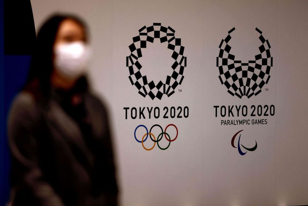 PHOTO: A woman wearing a face mask to protect against the novel coronavirus walks past logos of Tokyo 2020 Olympic and Paralympic Games in Tokyo, Japan, on Feb. 2, 2021.