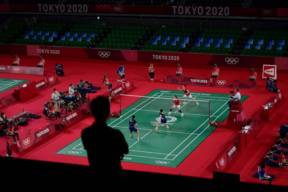 PHOTO: A member of the media watches as China's Chen Qingchen hits a shot next to China's Jia Yifan in their women's doubles badminton group stage match in Tokyo on July 27, 2021.