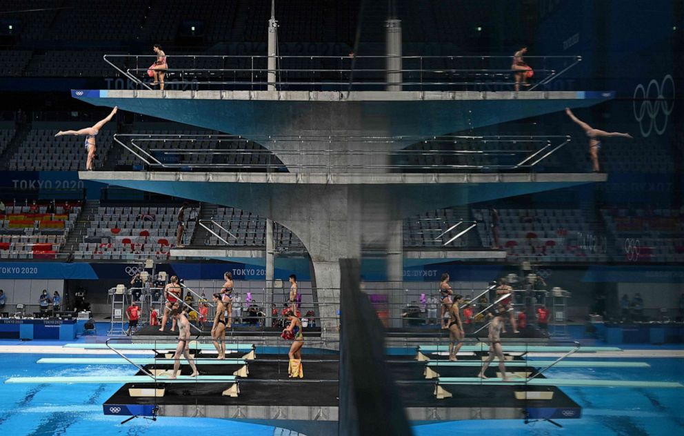 PHOTO: A picture shows the reflection of the boards as divers warm up  ahead of a diving session during the Tokyo 2020 Olympic Games at the Tokyo Aquatics Centre in Tokyo on July 27, 2021.