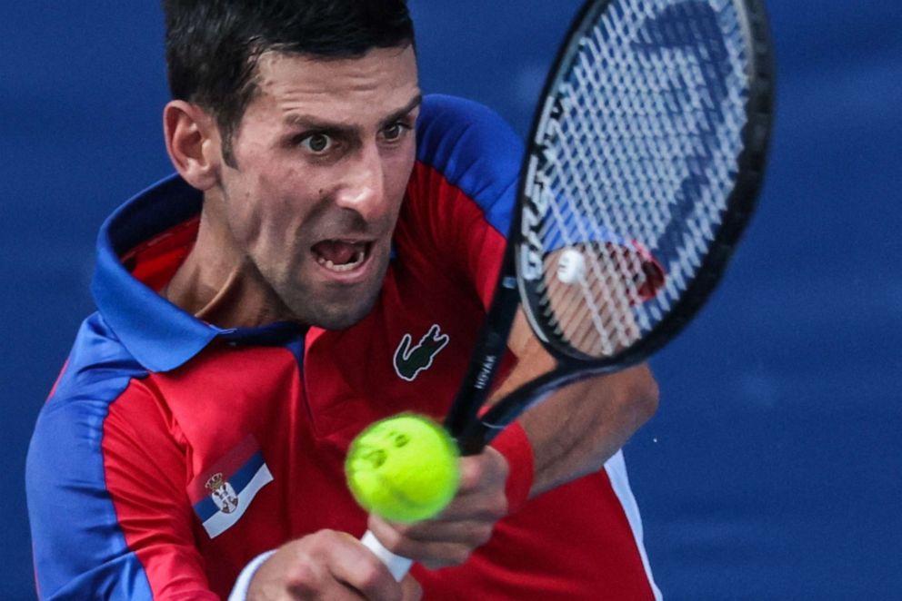 PHOTO: Serbia's Novak Djokovic returns a shot to Bolivia's Hugo Dellien during their Tokyo 2020 Olympic Games men's singles first round tennis match at the Ariake Tennis Park in Tokyo on July 24, 2021.