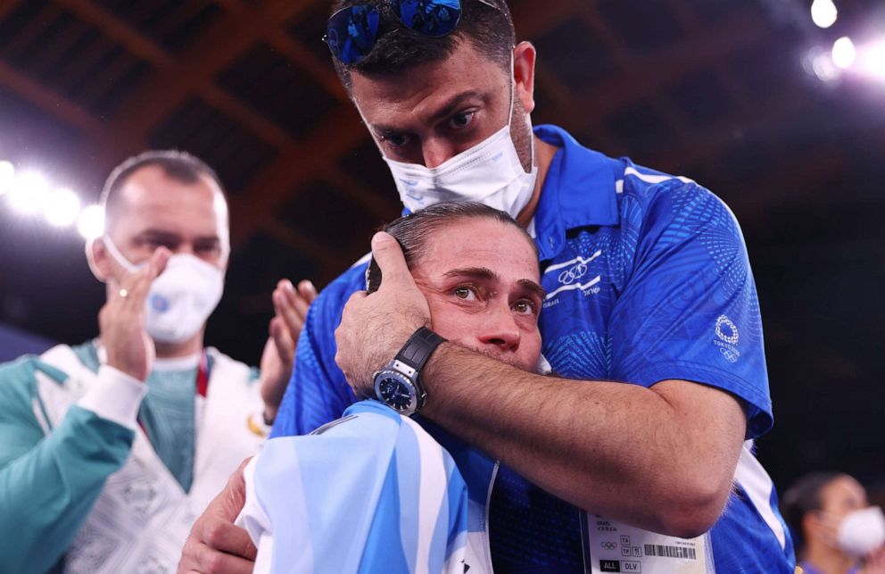 PHOTO: Oksana Chusovitina of Uzbekistan is embraced by Orabi Bader, physiotherapist for Israel, after performing on the vault on July, 25, 2021 in Tokyo.