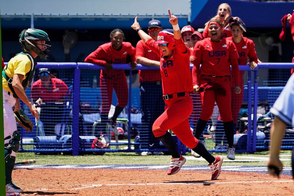 PHOTO: United States' Haylie McCleney scores the game winning run in front of Australia's Belinda White, left, in the eighth inning of a softball game at the 2020 Summer Olympics, Sunday, July 25, 2021, in Yokohama, Japan.
