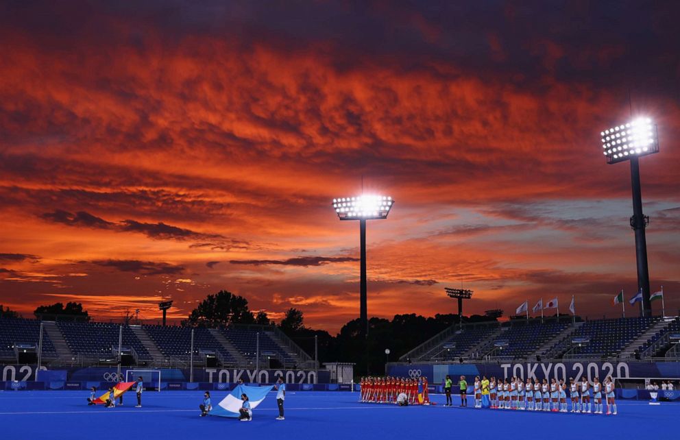 PHOTO: Spain and the players of Argentina sing their national anthems before their hockey match on July 26, 2021 in Tokyo.