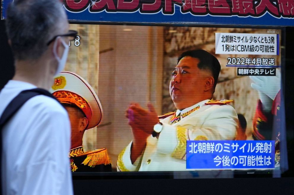 PHOTO: People moves past a tv screen showing the news report about North Korea's recent missile launches near Japan Thursday, Nov. 3, 2022, in Tokyo.