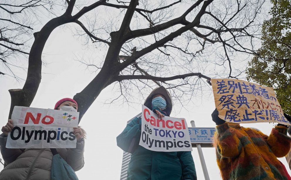 PHOTO: Demonstrators hold placards to protest against hosting the planned Tokyo 2020 Olympics near a building where organizing committee president Yoshiro Mori was to announce his resignation in Tokyo, Japan, on Feb. 12, 2021.