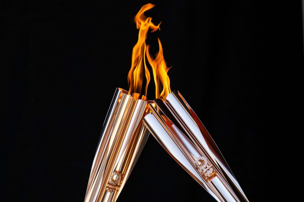 PHOTO: Torch bearers exchange the flame during the Olympic Torch Relay Celebration event on July 21, 2021 in Tokyo, Japan.