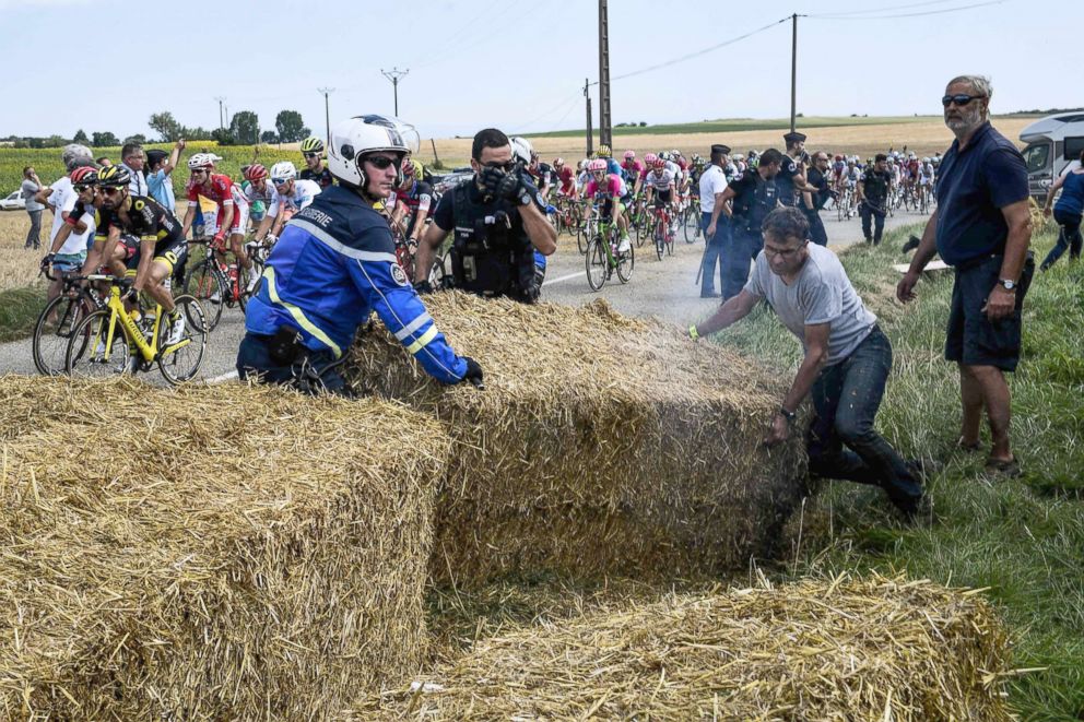 PHOTO: Gendarmes remove haystacks that were placed on the stage's route, during a farmers' protest who attempted to block the race, during the Tour de France cycling race, between Carcassonne and Bagneres-de-Luchon, southwestern France, July 24, 2018.
