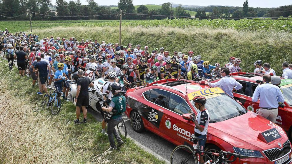PHOTO: The pack of riders wait for the stage to resume, after tear gas was used during a farmers' protest, during the Tour de France cycling race, between Carcassonne and Bagneres-de-Luchon, southwestern France, July 24, 2018.