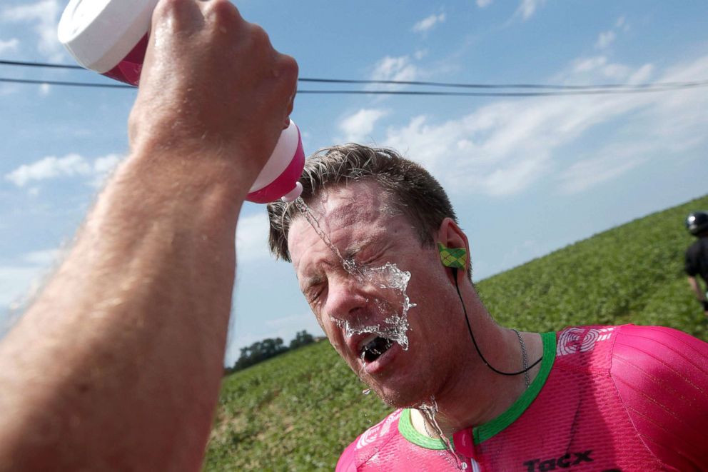PHOTO: Simon Clarke of Australia cleans his eyes after tear gas was used by policemen against the farmers who protested during the Tour de France cycling race between Carcassonne and Bagneres-de-Luchon, France, July 24, 2018.
